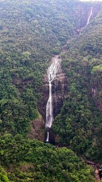 Cinematic aerial drone footage of Shangliar Falls, a stunning multi-tiered cascading waterfall located in Meghalaya, Northeast India, near the Sylhet border of Bangladesh.
