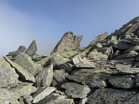 Rugged rock formations and giant granite boulders along a high-altitude hiking route in the Swiss Alps near Realp in the canton of Uri, showing steep cliffs, alpine terrain and dramatic mountain