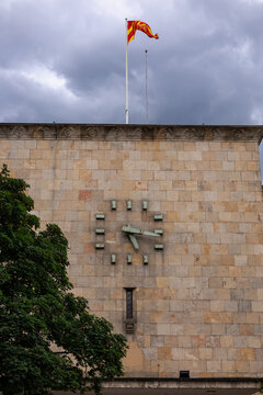 north macedonian flag waving atop the old railway station museum facade in skopje featuring its historic clock stopped at the 1963 earthquake time