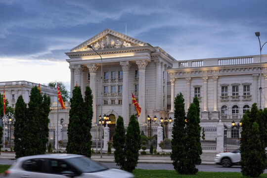 macedonian government building at dusk with waving flags, skopje architecture