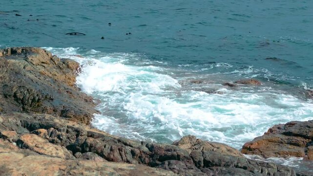 Ocean Waves Crashing on Rocky Shoreline with White Sea Foam