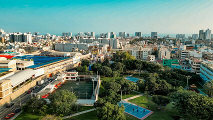 Obraz premium Aerial drone view of a vibrant public park featuring colorful outdoor sports courts and recreation areas near the coastline in San Miguel Lima