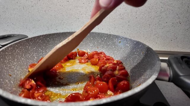 4K slow-motion footage of Pachino cherry tomatoes cooking in a pan to make a Mediterranean tomato sauce.