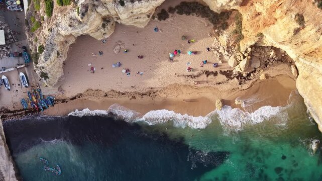 People relaxing on benagil beach in algarve, portugal
