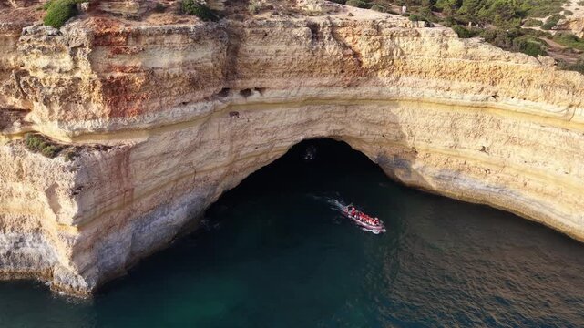 Tourists on a tour boat entering the benagil sea cave in algarve, portugal