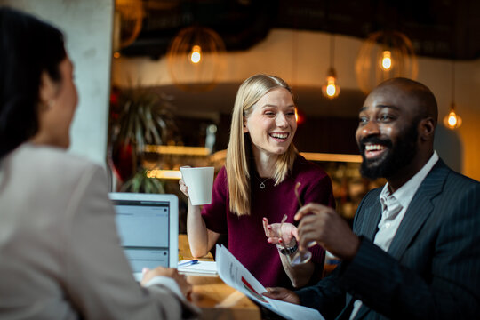 Business colleagues laughing during a meeting in a coffee shop