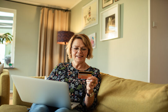 Smiling senior woman shopping online at home