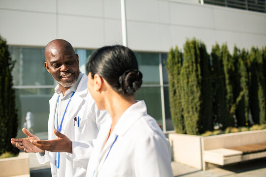Two doctors talking outside modern hospital