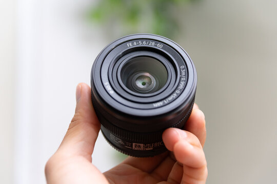 ZAPOPAN, MEXICO - SEPTEMBER 18, 2026: Hand holding Sony FE 28-60mm f/4-5.6 camera lens.