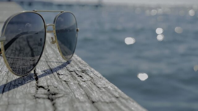 Aviator sunglasses resting on weathered wooden pier