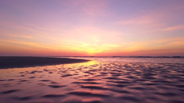 Quiet sandy beach at sunset glowing under soft pastel sky