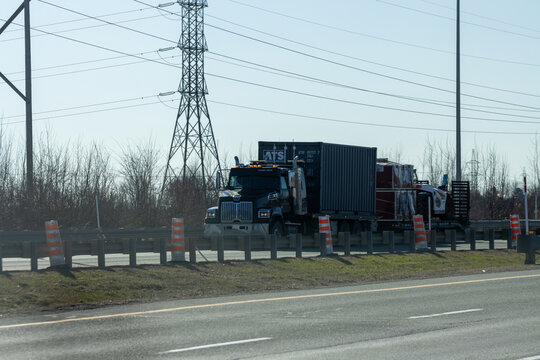 Quebec, Canada, 24 April 2026 : A Western Star semi-truck transports an ATS shipping container and other cargo on a highway