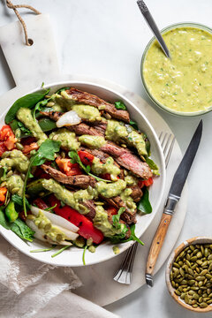 Above view of a homemade grilled fajita steak bowl with avocado dressing.