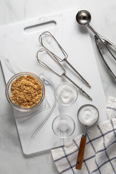 Tools and ingredients for baking, on a white marble cutting board.