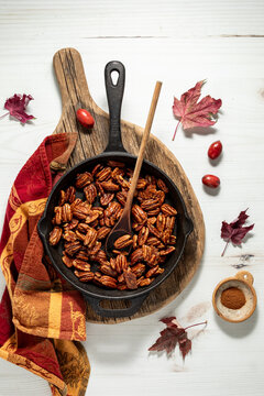 Above view of freshly made caramelized pecans in a cast iron frying pan.