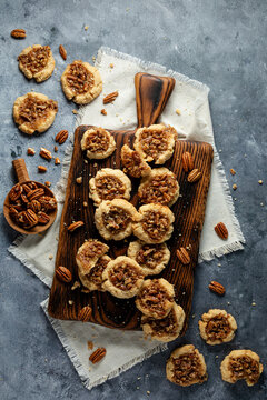 A styled arrangement of pecan pie cookies displayed on a wooden cutting board.