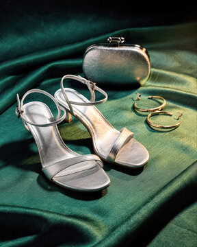 Silver Heeled Sandals Gold Hoop Earrings and Clutch on Emerald Silk
