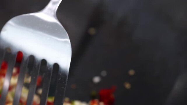 Cooking chopped chili and garlic in wok with metal spatula for spicy dish preparation.