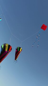 Giant colorful show kites with spinning windsock cones in blue sky