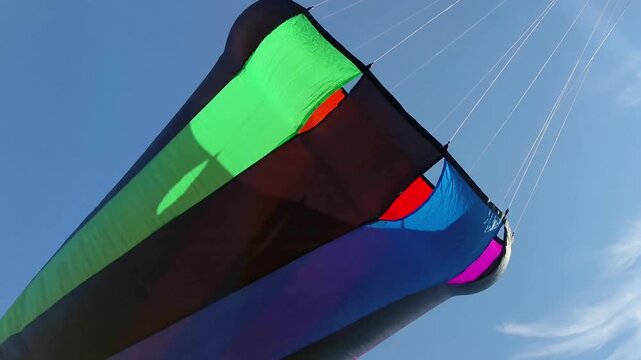 Giant colorful show kites with spinning windsock cones in blue sky