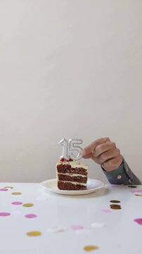 Hands Placing Number 15 Candle on Birthday Cake for Fifteenth Birthday Celebration