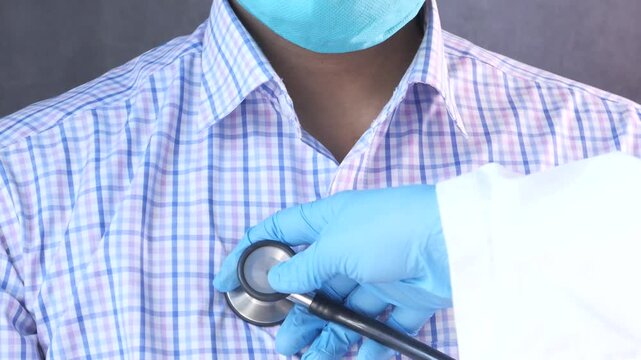 Close up of doctor hand with glove checking patient heart beat with stethoscope, health check up and medical concept