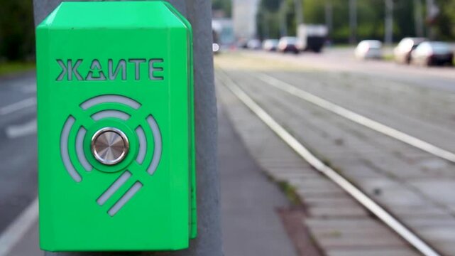 Green button for requesting public transport at a tram stop