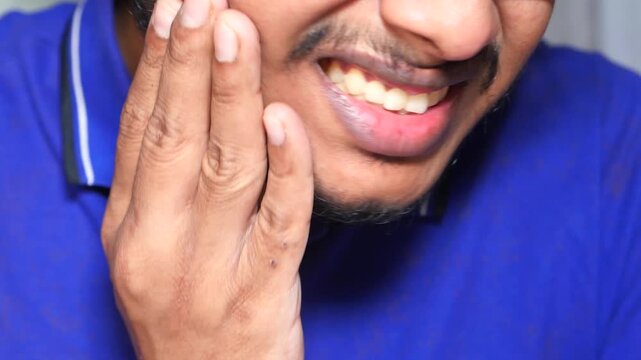 Young man experiencing severe toothache pain touching face with hand and showing discomfort outdoors closeup motion footage
