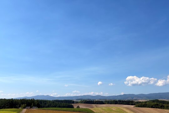 Patchwork fields and distant mountains in Biei, Hokkaido, Japan