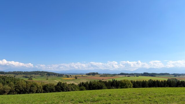 Patchwork farmland and mountain range in Biei, Hokkaido, Japan