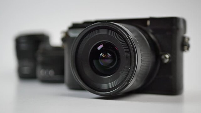 Close up shot of digital camera lens rotating on white background with selective focus