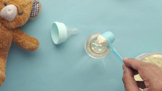 Preparing baby formula by adding powder to a bottle for infant feeding