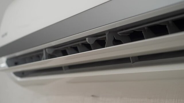 Air conditioner vent opening slowly in modern interior setting for temperature control