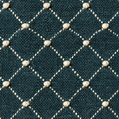 Obraz premium Seamless pattern teal woven fabric creating a background with a quilted diamond pattern. Cream colored knots accent the intersections of stitched lines