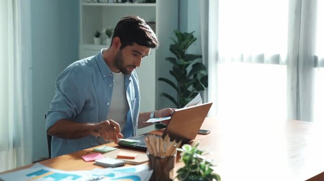 Professional smart manager working on laptop while looking at data analysis. Leader compare financial statistic graph while making decision at meeting table with document scatter around. Convocation.