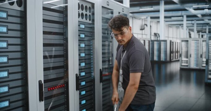 Vacuum Attachment Cleaning Dark Floor Tiles Right Beside Enterprise Server Cabinets. Routine Ground Level Dust Extraction Protects Sensitive Electronic Infrastructure From Particulate Contamination.