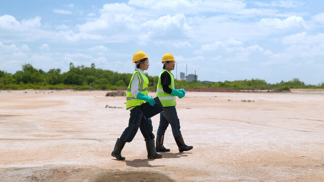 Certified Environmental Scientists in Protective Gear Walking Across Arid Land for Soil Contamination Survey 4K
