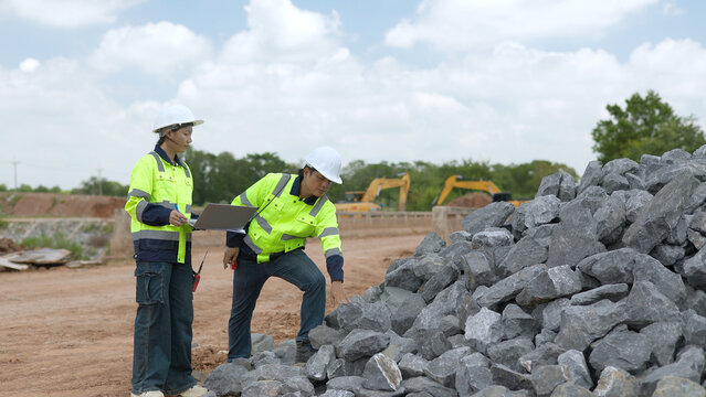 Certified Civil Engineers Inspecting Aggregate Rock Pile Quality with Laptop at Road Construction Site 4K