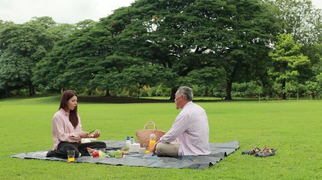 Father, Little girl walking and spending time with father in the park. Happy Asian family having fun time on picnic at city nature park, outdoor activitie