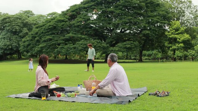Father, Little girl walking and spending time with father in the park. Happy Asian family having fun time on picnic at city nature park, outdoor activitie