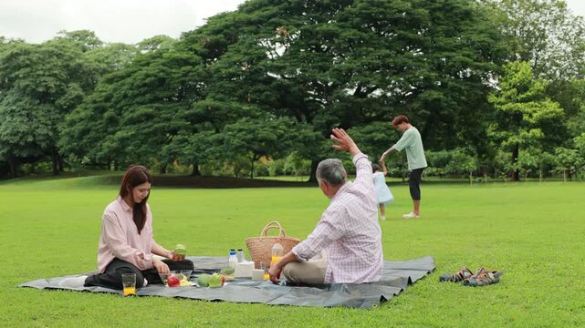 Father, Little girl walking and spending time with father in the park. Happy Asian family having fun time on picnic at city nature park, outdoor activitie