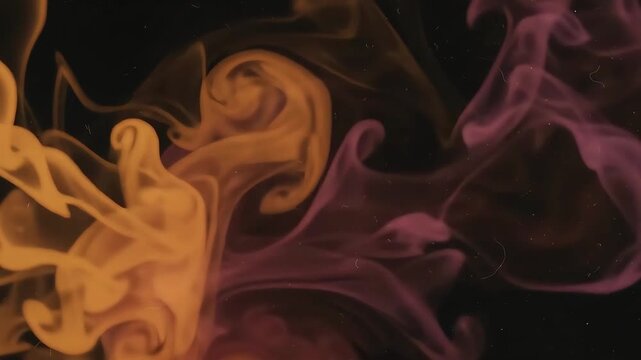 Abstract swirling clouds of amber and magenta ink diffuse smoothly through dark liquid, creating vibrant organic patterns.
