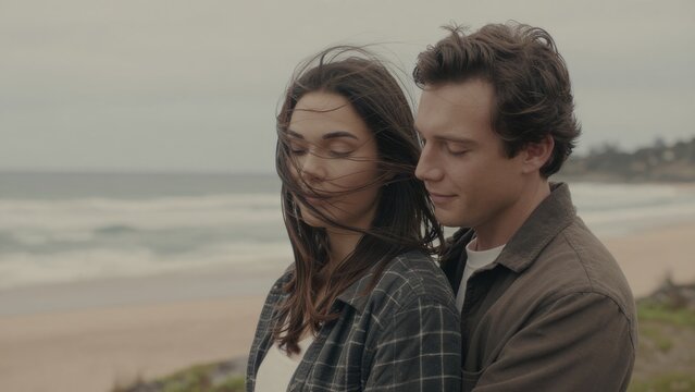 Romantic couple embracing on a beach with ocean waves in background