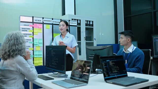 A diverse team of software developers collaborates on agile project management, brainstorming strategies at a kanban board in a modern tech office.