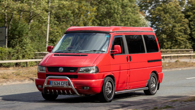 Milton Keynes; UK - Aug 30th 2026: 1999 red Volkswagen Caravelle camper van driving on a British road