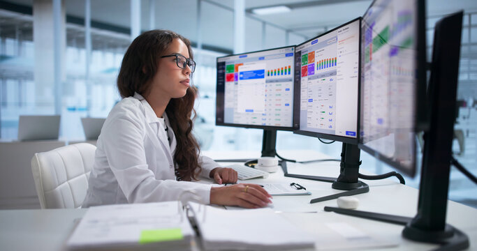 Pharmacy Manager Reviews Medication Stock On Computer