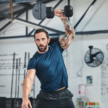 Strong, man and workout in gym with dumbbell, weightlifting and functional training for bodybuilder. Person, fitness and strength exercise in health club with equipment, bodybuilding and wellness.