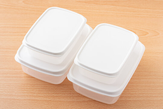 木製テーブルに重ねたふた付き食品保存容器