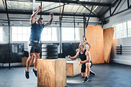 People, gym and jump box with workout for fitness, exercise and motivation for training achievement. Athlete, group and personal trainer for health, fist pump and performance on wood crate for cardio
