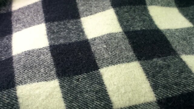Synthetic material, checked black and white blanket close up shot for background.